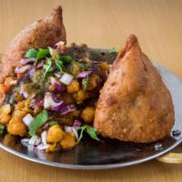 Samosa Chaat
 · Samosa, chickpeas, onion and tomatoes topped with tamarind and cilantro chutney.