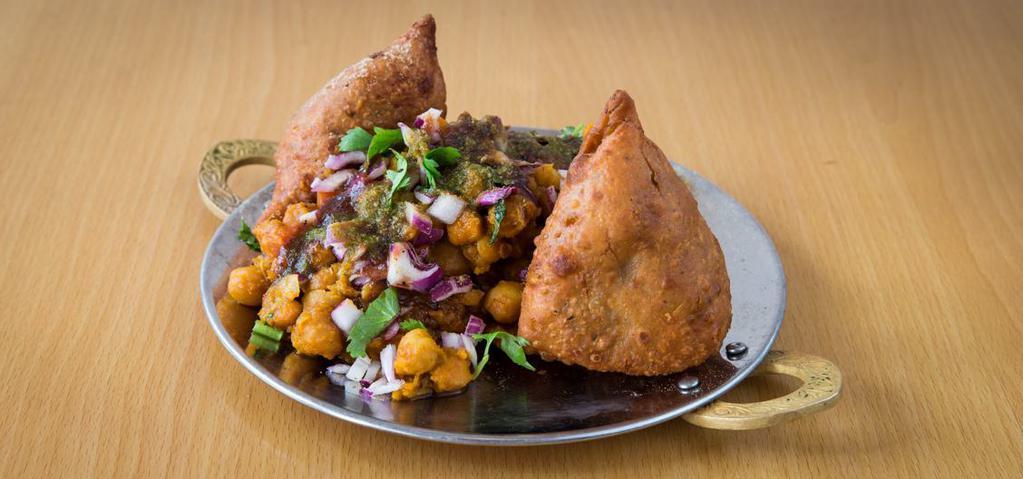 Samosa Chaat
 · Samosa, chickpeas, onion and tomatoes topped with tamarind and cilantro chutney.