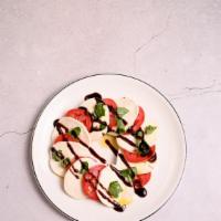 Caprese Salad · Fresh mozzarella, roma tomatoes, fresh basil, olive oil, balsamic reduction, salt, and pepper.