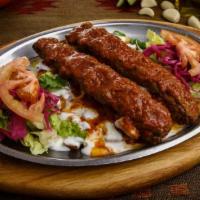 Yogurtlu Adana · Two skewers of Adana kebab, layered on diced butter-roasted pide bread, topped with yogurt a...