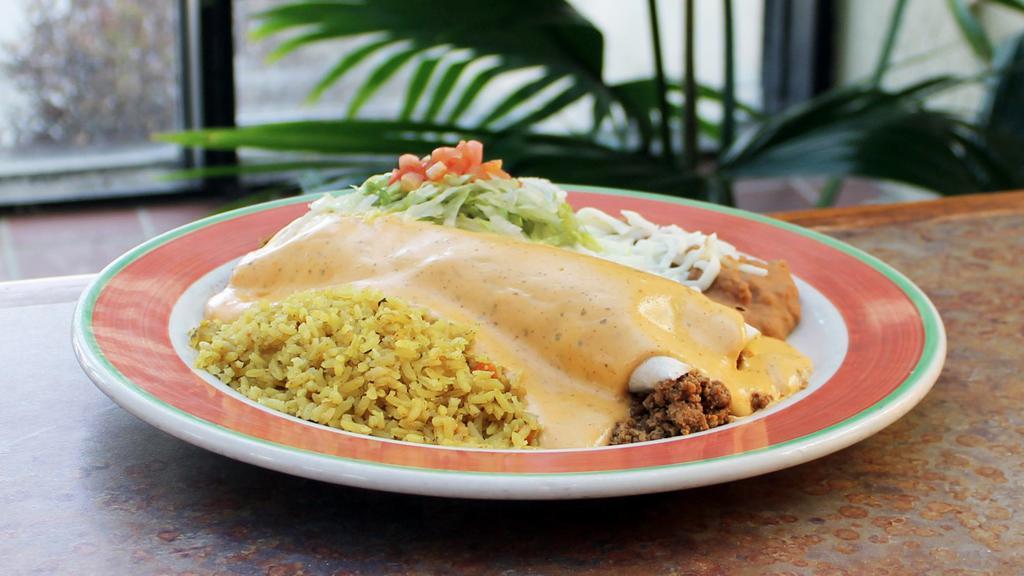 Burrito Con Queso · There's only one way to make our burritos better, smother them in our incredible zesty cheese sauce and serve them with Spanish rice and your choice of beans. Choose beef or chicken. Substitute Spanish rice and beans with our fresh, seasoned and grilled vegetable mix for .99.