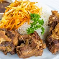 Dakar Oxtails · Slow-braised oxtails served with shredded carrots and cabbage and a side of your choice.