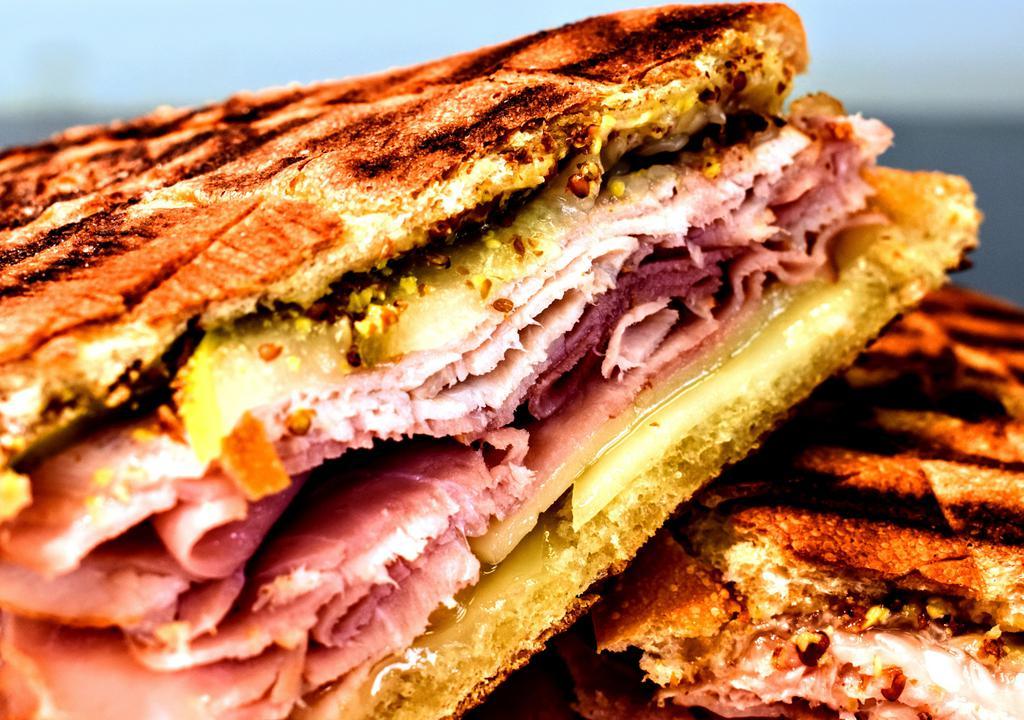 Cuban Panini · Roasted pork, smoked ham and cheese swiss cheese with sliced dill pickles, whole grain mustard and spices.
