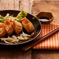 Potstickers · Seven potstickers with soy sauce.