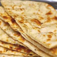 Naan · Unleavened bread freshly baked in traditional clay oven.