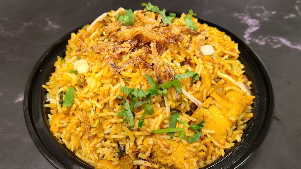 Chicken Biryani · A classic dish cooked with chicken, nuts and raisins with basmati rice. Served with raita.