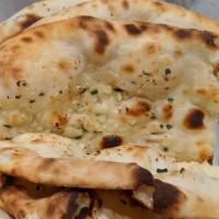 Garlic Naan · Leavened flatbread with butter, garlic and chives cooked in the tandoor.