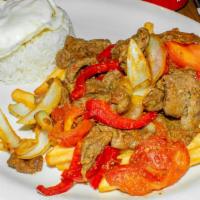Lomo Saltiado · Steak strips with onion and tomato, with French fries and rice.