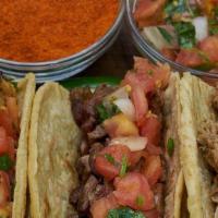 Tacos De Brisket / Brisket Tacos · Tres tacos de falda en tortilla de harina con pico de gallo, jalapeños y queso rallado servi...