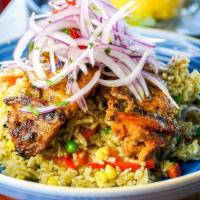 Arroz Con Pollo · “Rice & Chicken” simmered in cilantro, herbs and vegetables.