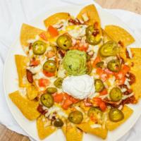 Nachos Grande · Crispy tortilla chips smothered with chili and melted Cheddar-Jack cheese. Topped with sour ...