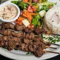 Lamb Kebab Platter · Marinated cubes of lamb grilled on a skewer. Served with rice or hummus, lettuce, tomato, pi...