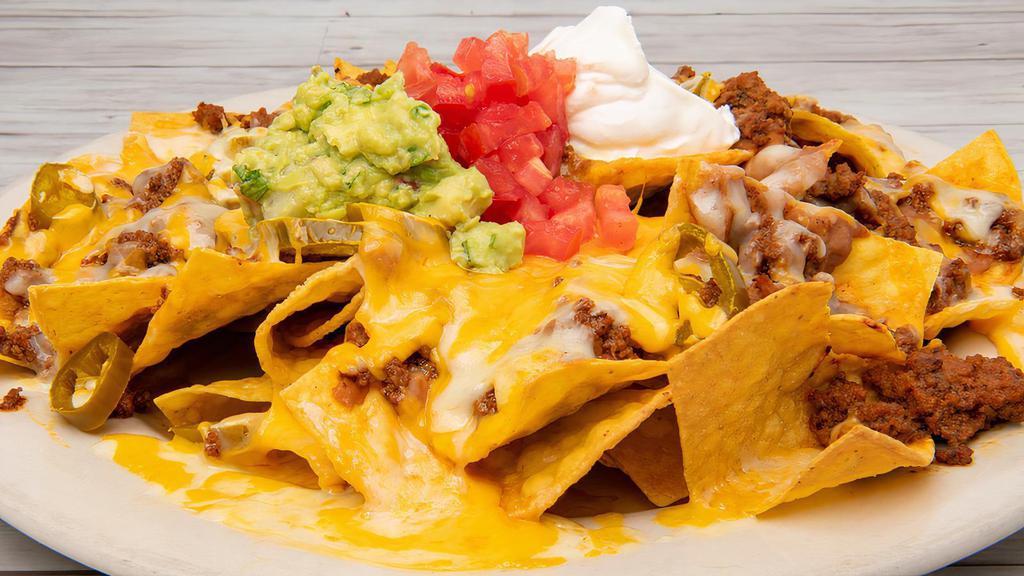 Super Nachos · Tortilla chips covered in nacho cheese with ground beef, refried beans, shredded cheese, sour cream and salsa.