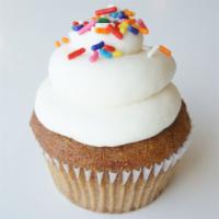 Golden Vanilla Cupcake · Our golden vanilla cake topped with a classic buttercream and garnished with a dash of rainb...
