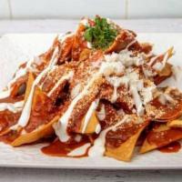 Chilaquiles Rojos · Crispy tortillas cooked with Red guajillo sauce topped with cotija cheese, sour cream, avoca...