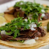 Tacos · Tortillas filled with choice of Protein with cilantro and onions comes with green avocado sa...