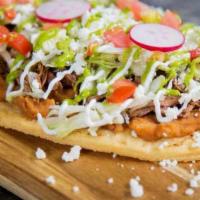 Huarache · Large handmade tortilla topped with beans, lettuce, sour cream, queso fresco with choice of ...