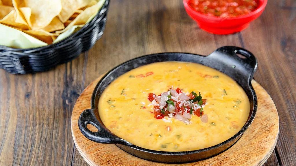 Queso Dip · Two cheese blend, pico de gallo, roasted pasilla peppers and cilantro.  Served with warm tortilla chips.