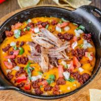 Queso Dip With Carnitas · Two cheese blend, pico de gallo, roasted pasilla peppers, cilantro and carnitas.  Served wit...