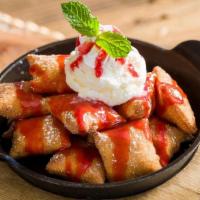 Straberry Sopapillas · Mexican pastry drizzled with strawberry sauce and topped with vanilla ice cream & cinnamon w...