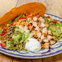 Grilled Chicken Taco Salad · Homemade tostada taco shell filled with romaine lettuce, refried beans, pico de gallo, cotij...