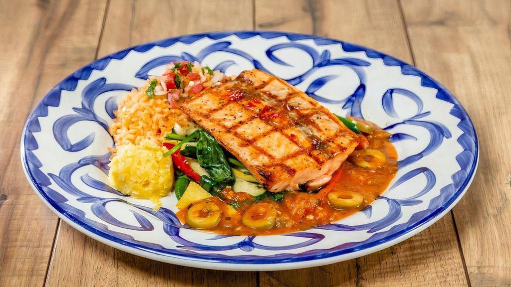 Salmon Veracruz · Grilled filet of salmon in jalapeño butter with salsa Veracruz, served atop fresh spinach and sautéed vegetables. Served with rice and pico de gallo.