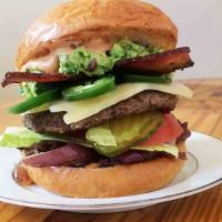 The Oaxaca Burger · A towering burger with cheddar, bacon, guacamole, jalapenos, caramelized onions-black pepper...