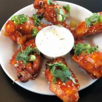 Korean Chicken Wings · Tangy, spicy, delicious, and very Korean. Served with scallions, toasted sesame seeds, and c...