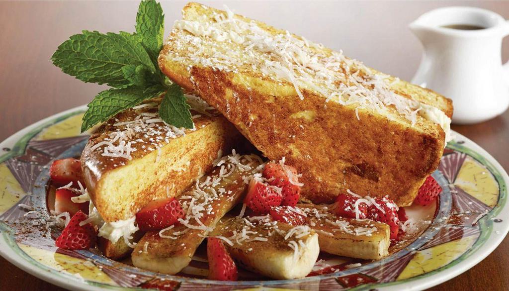 Coconut Cream Stuffed French Toast · Challah Bread dipped in Egg Mix, stuffed with Coconut Cream Cheese & Flaked Coconut, garnished with Diced Strawberries & Brûléed Bananas, dusted with Cinnamon & Powdered Sugar