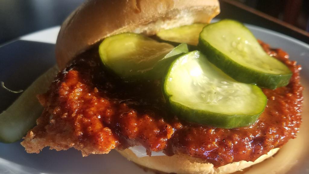 Nashville Hot Chicken · Hand breaded crispy chicken breast tossed in Nashville Hot sauce topped with house made bread and butter pickles served with mayo on a homestyle bun.