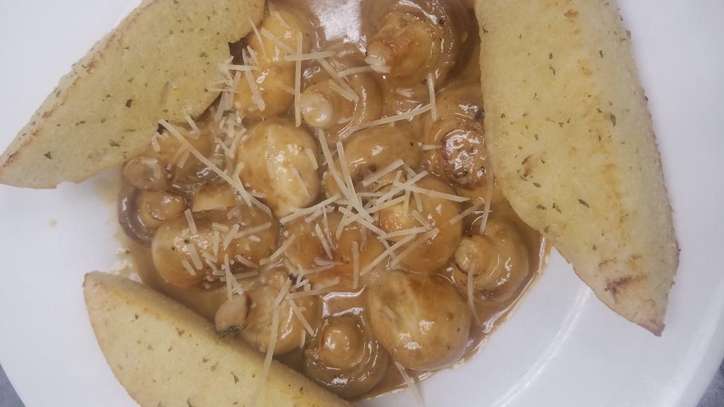 Smothered Mushrooms · Whole button mushrooms sautéed in butter, garlic, and chardonnay, then finished with a touch of cream and parmesan cheese. Served with garlic toast points for enjoying this delicate sauce.