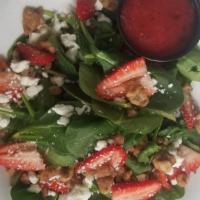 Strawberry Spinach Salad · Fresh baby spinach, sliced strawberries, candied walnuts, and creamy feta cheese, served wit...