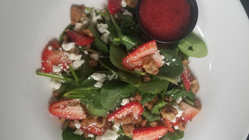 Strawberry Spinach Salad · Fresh baby spinach, sliced strawberries, candied walnuts, and creamy feta cheese, served with wild raspberry vinaigrette.