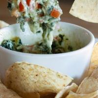 Spinach Artichoke Dip · A creamy blend of spinach, artichoke hearts, melted Parmesan and Provolone cheese. Served wi...