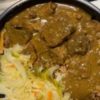 Curry Goat With Rice And Beans · Goat seasoned then sauteed and slowly cooked in a zesty curry gravy. Served with rice, cabbage