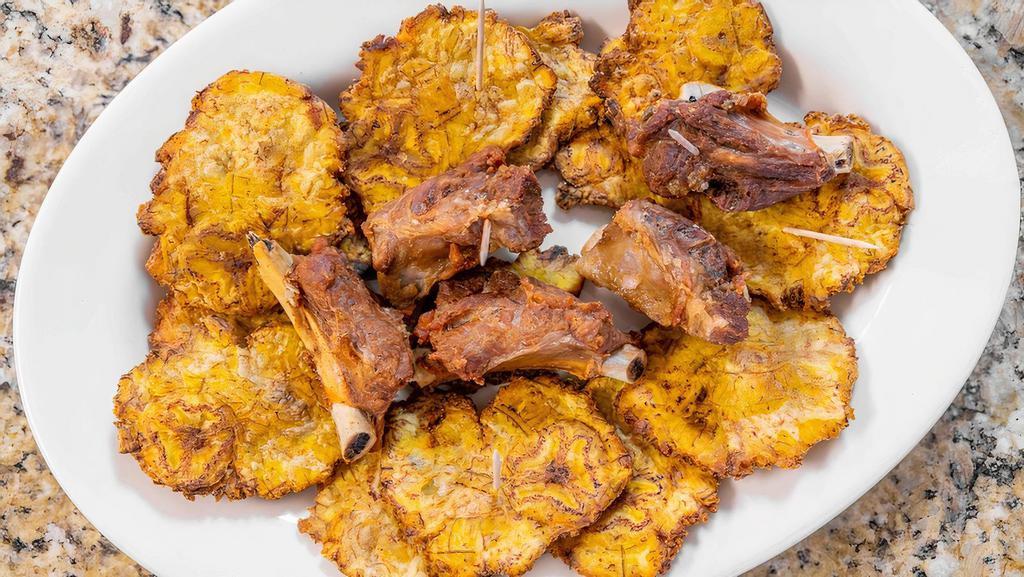 Patacones Con Chicharrón · Fried plantains with pork rinds.