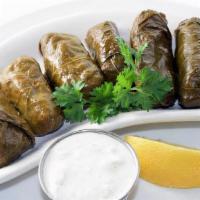 Dolmades · Grape leaves stuffed with a blend of seasoned ground beef, rice, and herbs. Braised delicate...