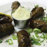 Salmon Dolmas · Fresh salmon filets seasoned and wrapped in grape leaves. Broiled and served with skordalia ...