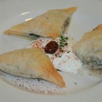 Spanakopita* · Mixture of spinach, feta cheese and spices wrapped in delicate phyllo dough baked until gold...