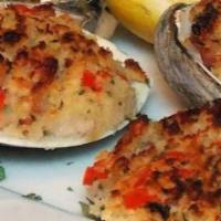Clams Casino · Fresh clams topped with crispy bacon and herbs, then toasted with breadcrumbs.