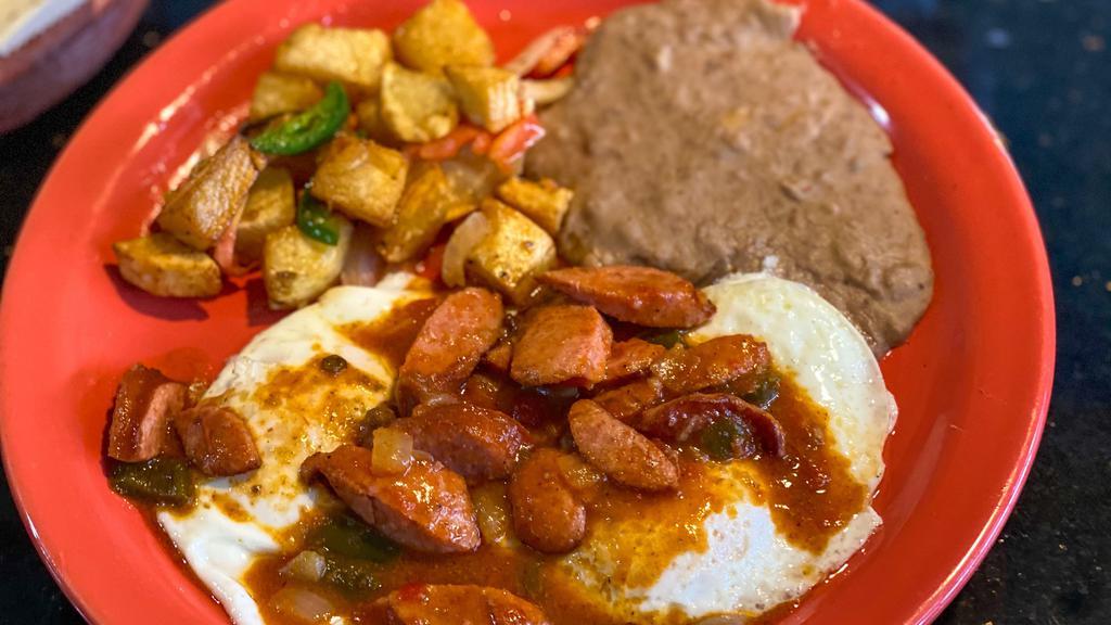 Pancho Villa Specialty · Two eggs your choice, topped with country sausage guisado, served with refried bean and papas fritas.
