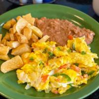 Huevos A La Mexicana · Eggs mixed with tomatoes, onions and chile; served with beans and potatoes.