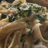 Classic Fettuccine Alfredo · Fettuccini noodles in a creamy white wine sauce topped with shaved pecorino and fresh herbs