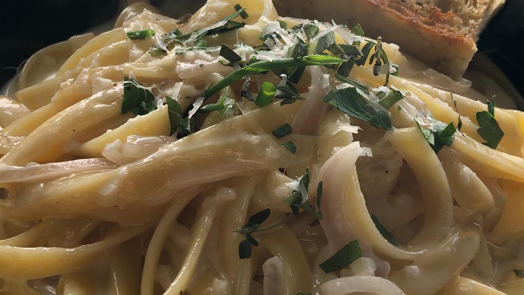 Classic Fettuccine Alfredo · Fettuccini noodles in a creamy white wine sauce topped with shaved pecorino and fresh herbs