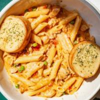 Blackened Chicken Penne · Cajun seasoned baked chicken breast and penne tossed with tomatoes and peas in a Parmesan he...