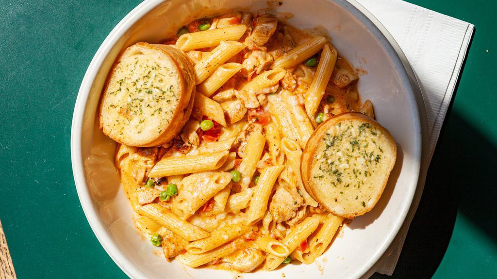 Blackened Chicken Penne · Cajun seasoned baked chicken breast and penne tossed with tomatoes and peas in a Parmesan herb butter cream sauce.