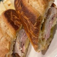 Cuban Sandwich · Turkey, black forest ham, melted Swiss, bread and butter pickles and mustard on a flat grill...
