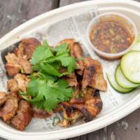 Moo Yang Kati · Grilled pork marinated in creamy coconut milk served with spring mix and spicy tamarind sauce.