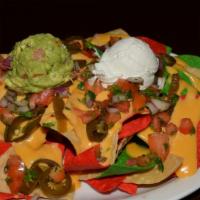 Loaded Nachos · Guacamole, Pico De gallo, sour cream melted cheese, Jalapeños served on three colors of tort...