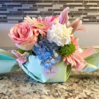 Candy Bouquet  · This unique arrangement comes in a candy shaped wrap with a fresh selection of pastel flowers!